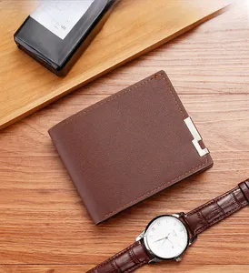 Detail of dark brown leather bi-fold wallet with orange stitching and metal trim