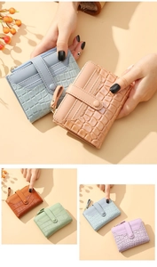 Detail of crocodile pattern wallets showing multiple card slots and snap button closures