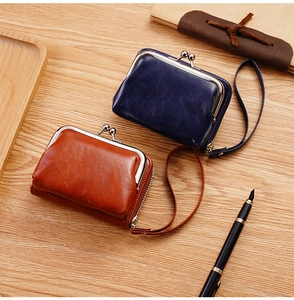 Dettaglio di portafogli vintage in ecopelle con chiusura a scatto e zip su legno