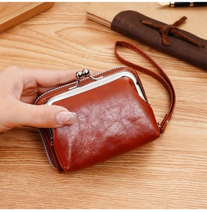 Dettaglio del portafoglio vintage marrone rosso con chiusura a scatto e cinturino