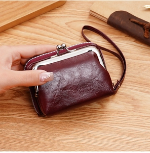 Dettaglio di un mini portafoglio bordeaux con chiusura vintage e tasca con zip