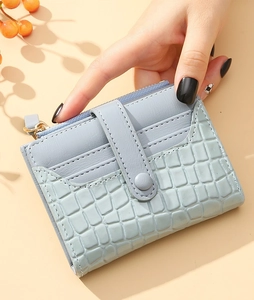 Close-up of light blue crocodile texture card holder with multi-slot design and snap closure