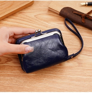 Dettaglio portamonete vintage blu scuro in ecopelle con chiusura a scatto e cinturino