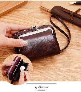 Dettaglio del portamonete vintage in pelle cerata con chiusura a scatto su legno