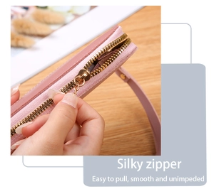 Detail of a smooth gold metal zipper on a pink lychee grain leather wallet