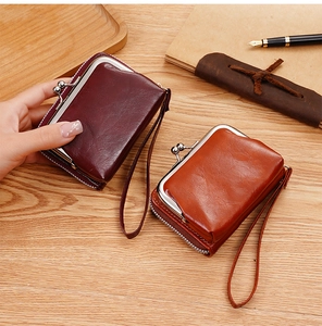 Portamonete classici in pelle con chiusure in metallo e cinturini su scrivania vintage