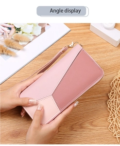 Detail view of pink patchwork long wallet with pebbled texture and wrist strap
