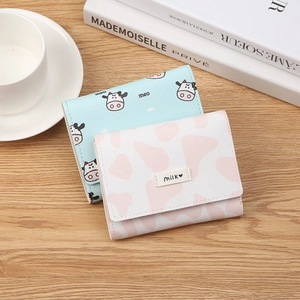 Three-fold PU leather mini wallets featuring cartoon cow patterns on a wooden desk setup