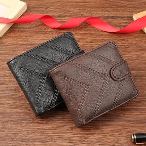 Detail view of black and brown leather wallets with woven V-pattern on wood surface
