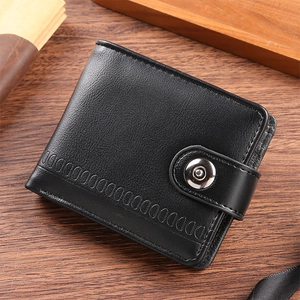 Detail of black pebbled leather wallet with snap closure on a professional wooden desk