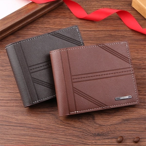 Close-up of litchi texture leather wallets with contrast stitching on dark wood