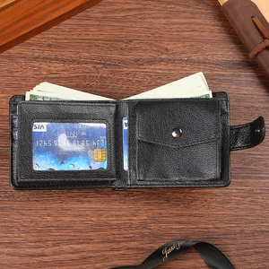 Classic black bifold leather wallet with coin pocket and card slots on dark wooden desk