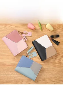 Detailed view of color-block short wallets with tassel zippers and rabbit charms