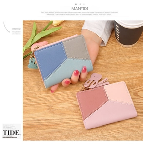 Detail view of compact multi-color wallets with rabbit charms on a wooden surface