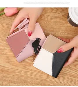 Detailed view of color-block zip wallets with pebble leather texture and tassel charms