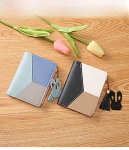 Detail of color-block minimalist wallets with tassel and cute rabbit leather charms