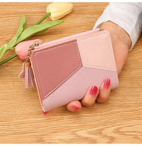 Detailed view of pink patchwork wallet with gold zipper and stylish tassel charm