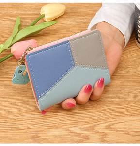 Detail of color-block short wallet with metal zipper and rabbit charm in hand