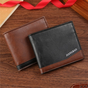 Close-up of brown and black leather bifold wallets on a wooden surface with gift decor
