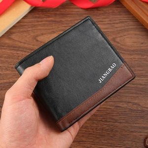 Men's bifold wallet in black litchi and brown leather texture being held by hand