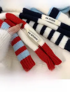 Gros plan d'une écharpe en maille rayée rouge, blanc et bleu avec texture moelleuse