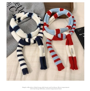 Détail d'écharpes en maille à rayures colorées avec motif bleu marine, rouge et blanc