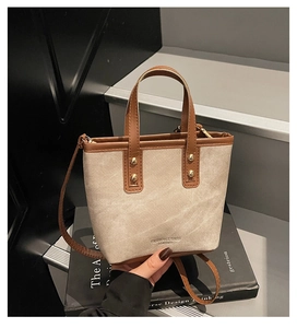 Detail der Vintage-Canvas-Tasche mit braunem Lederbesatz und Goldnieten-Akzenten