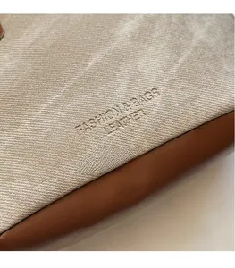 Nahaufnahme der Canvas-Beuteltasche mit Lederbesatz und geprägtem Fashion-Schriftzug