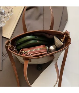 Draufsicht auf das geräumige Tascheninnere aus Canvas und braunem Leder mit persönlichen Sachen