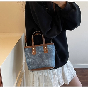 Blue denim texture tote bag with brown leather handles and adjustable shoulder strap