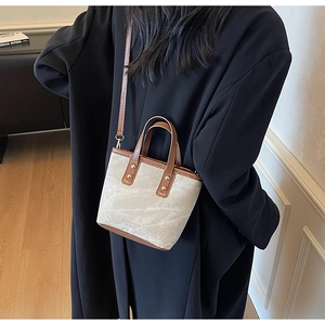 Detail einer grauen Stoff- und braunen Leder-Beuteltasche getragen von einem Model
