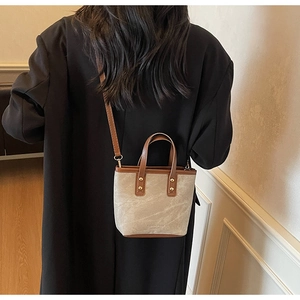 Woman wearing gray marble texture handbag with brown leather straps in a casual outfit