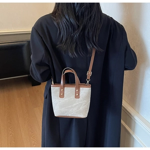 Detail of color-block tote bag showing fashion leather texture and brown handle accents