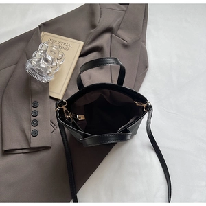Vue de dessus d'un sac seau noir avec zip doré et compartiment intérieur spacieux