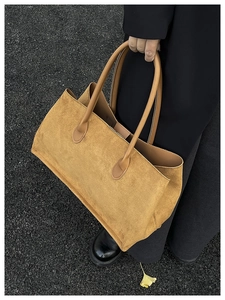 Détail du sac cabas en velours côtelé camel montrant la texture douce et les anses