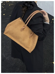 Brown vintage suede tote bag styled with a black blazer on a model for a chic commute
