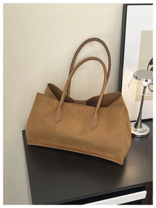 Macro detail of brown suede tote bag with slim shoulder straps for chic daily commuting