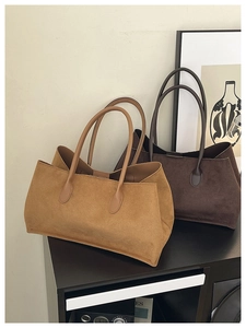 Close-up of camel and dark brown suede tote bags with slender shoulder straps