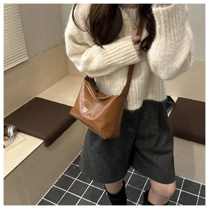 Brown leather tote bag worn by model with adjustable strap for casual commute fashion