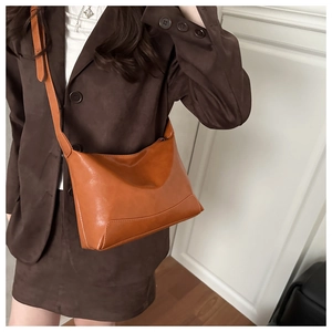 Detail view of reinforced stitching and adjustable strap on a vintage caramel tote bag