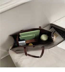 Spacious interior of a vintage brown leather tote bag with tablet and daily essentials