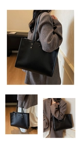 Close-up of large black vintage tote bag featuring matte leather and gold rivet details