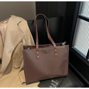 Detail of vintage dark brown tote bag with gold rivets on premium matte PU leather