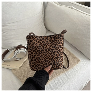 Close-up of leopard print crossbody bag with plush texture and slim leather strap
