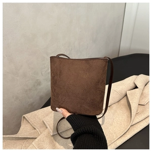 Detail of a deep coffee matte bucket bag showing the texture and compact rectangular shape