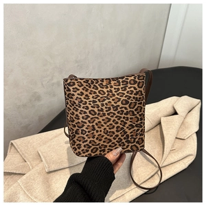 Detailed view of fashionable leopard print bucket bag with brown faux leather strap