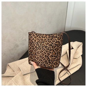 Close-up of leopard print bucket bag with textured faux fur and brown shoulder strap