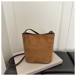 Detailed close-up of brown suede bucket bag texture on a minimalist lifestyle background