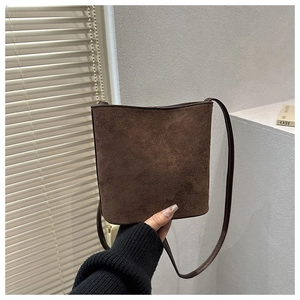 Detail of dark brown matte bucket bag in premium faux suede with slim shoulder strap