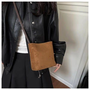 Detailed view of a brown suede bucket bag featuring a soft matte texture and minimalist design